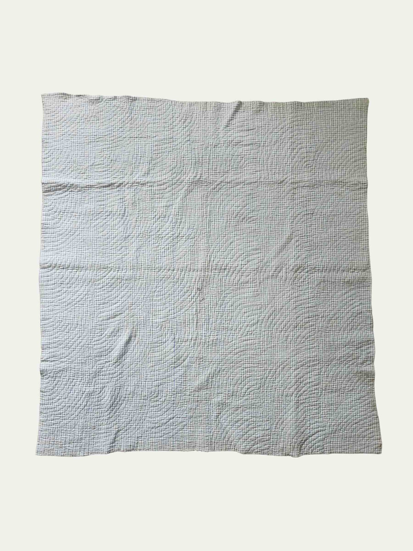 Textured gray quilt on a white background