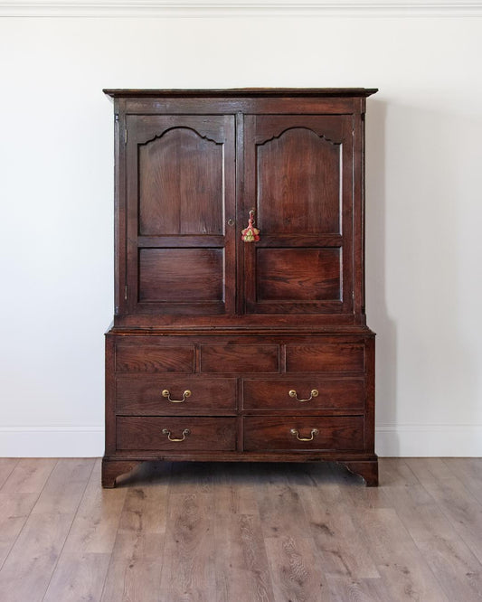 antique English oak cupboard with paneled doors and drawers