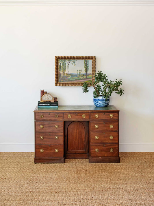 Wooden desk with decorative items against a white wall