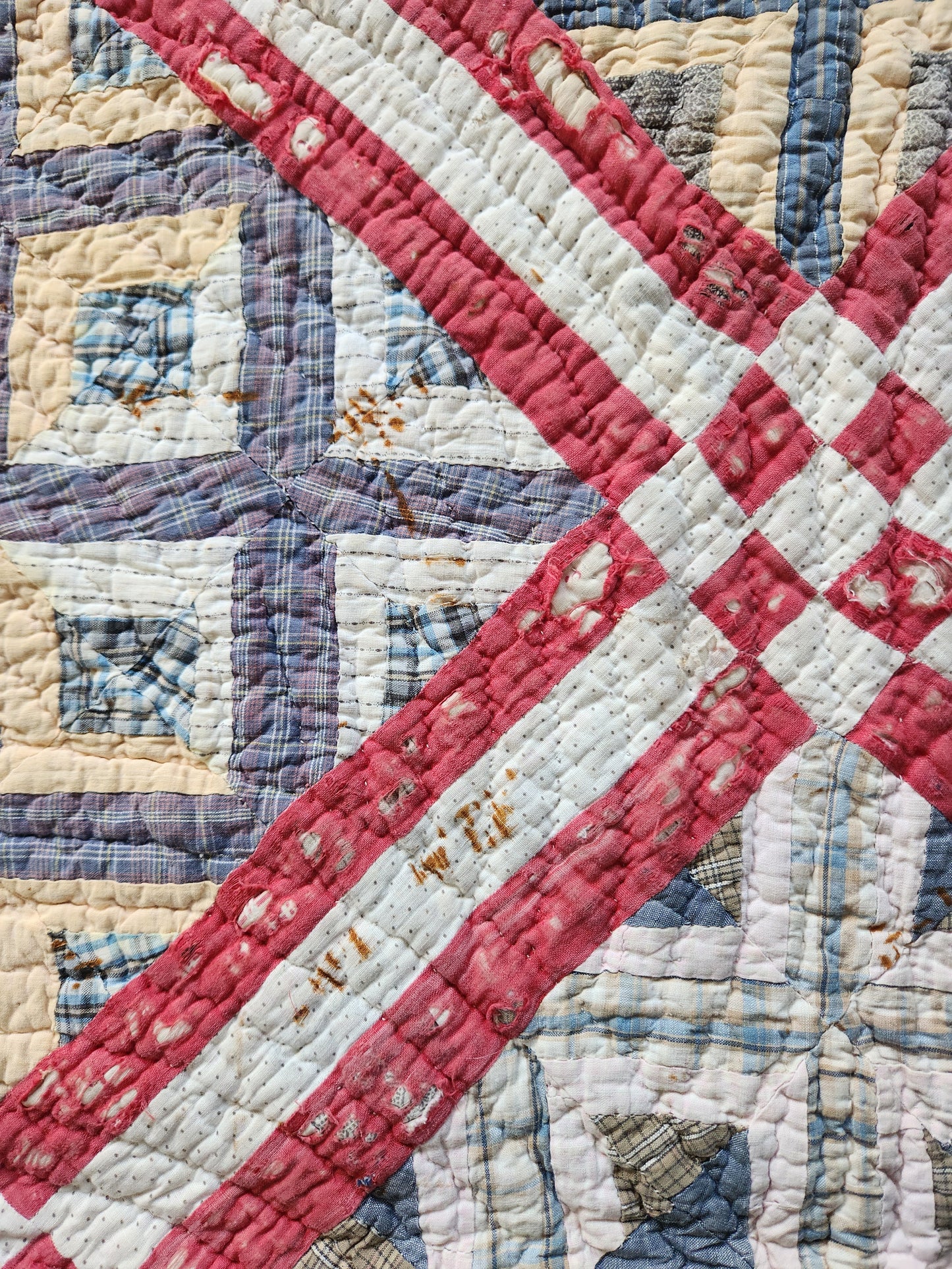 Close-up of a patchwork quilt with a red diagonal stripe