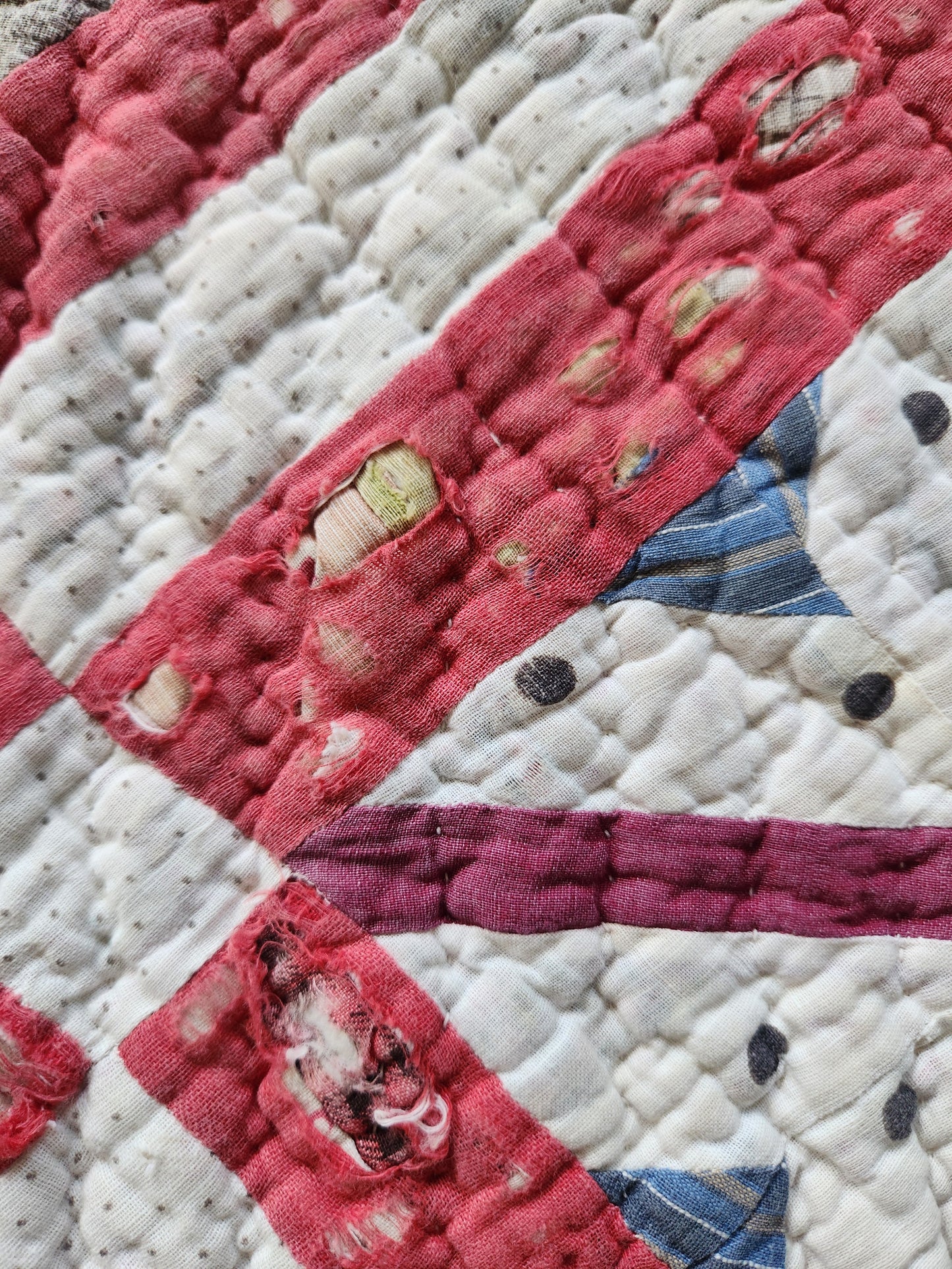 Close-up of a quilt with red, white, and blue patterns