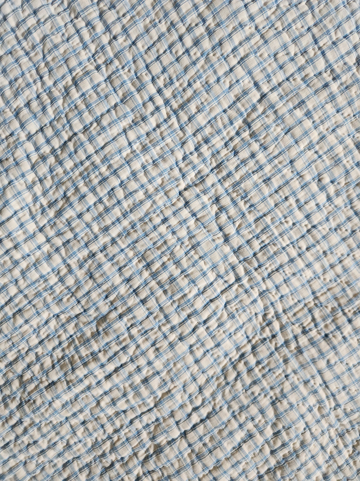 Textured fabric with blue and beige checkered pattern