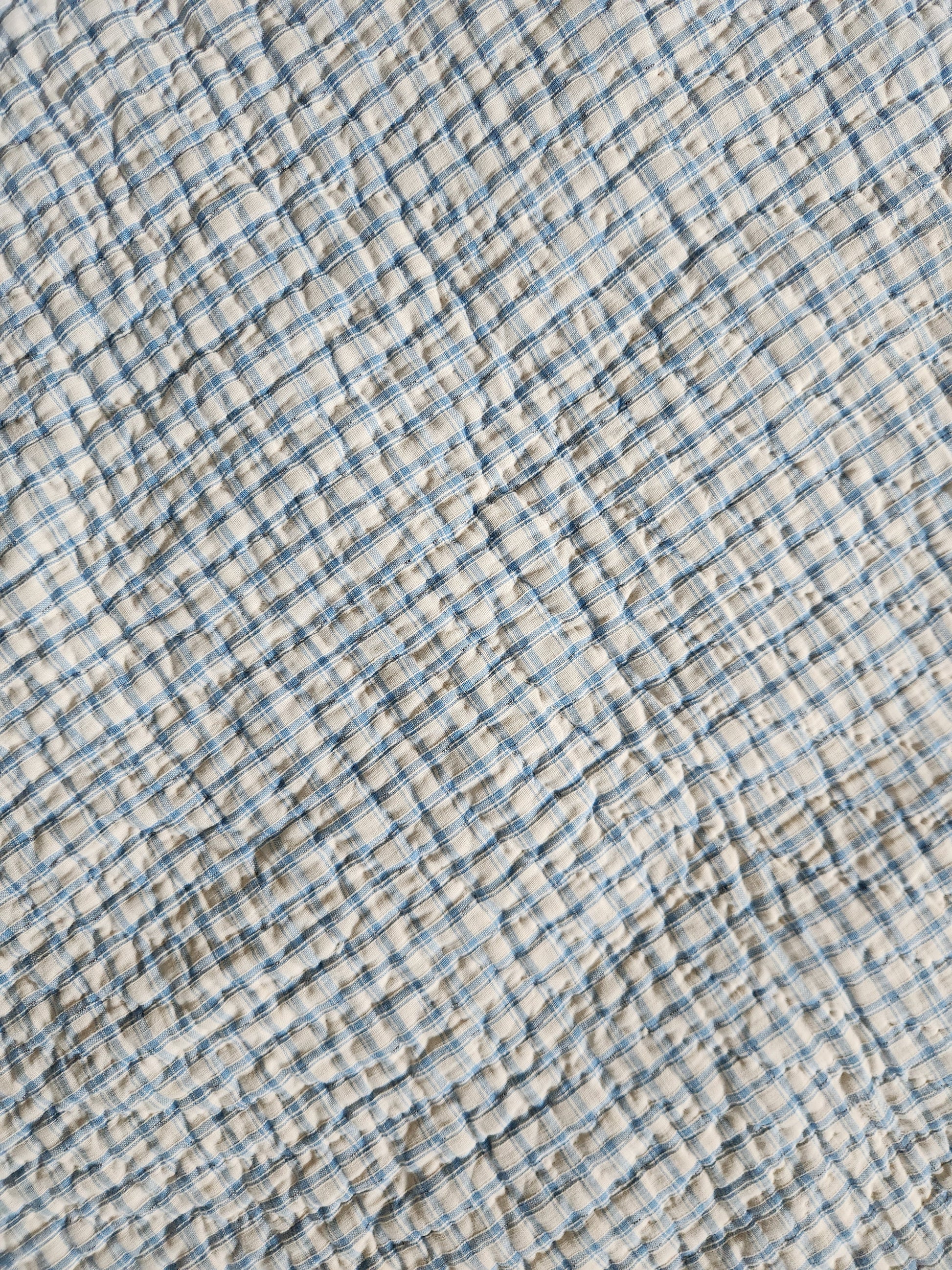 Textured fabric with blue and beige checkered pattern