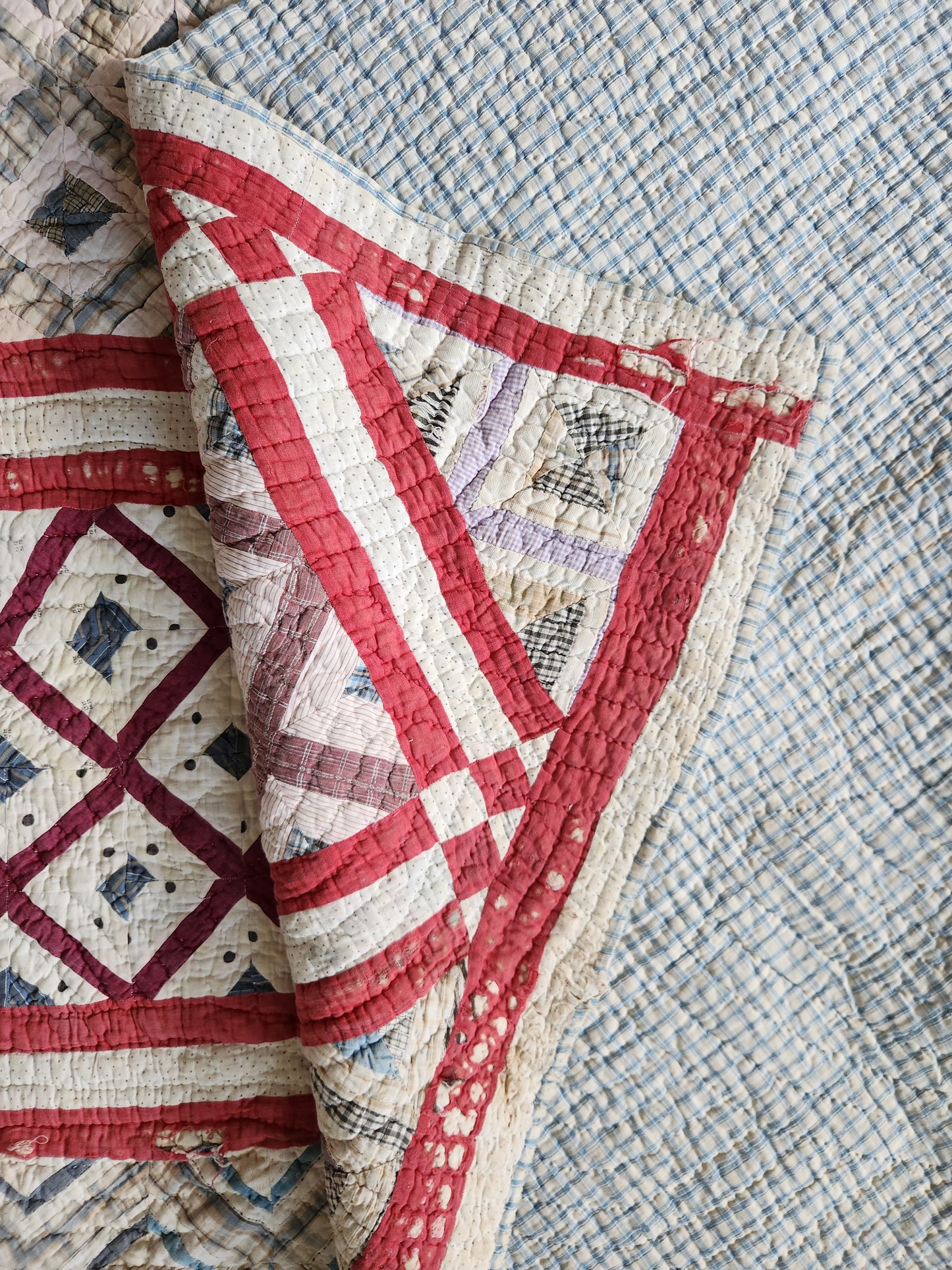 Close-up of a quilt with red and white patterns on a textured surface
