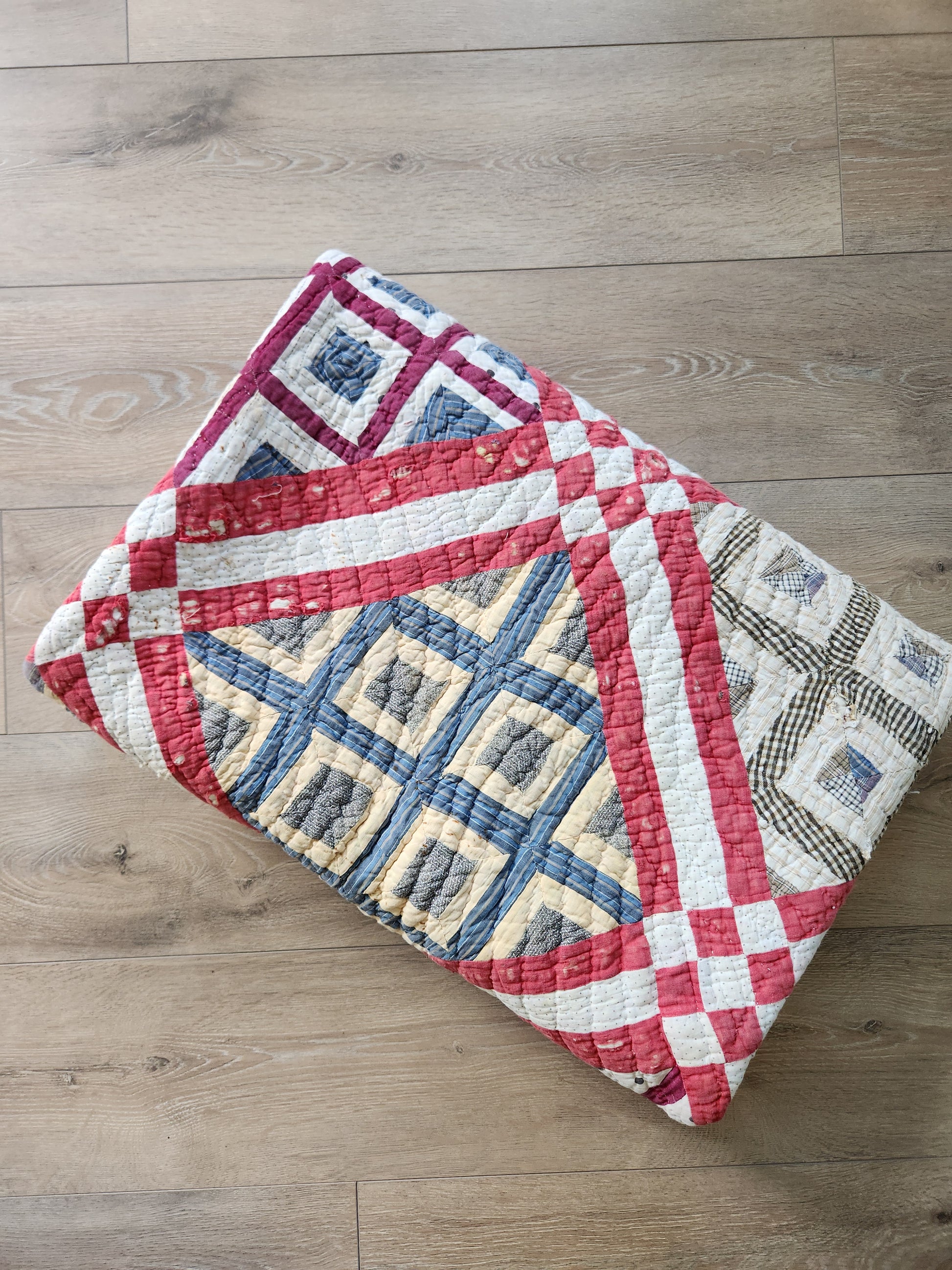 Quilt with geometric pattern on a wooden floor