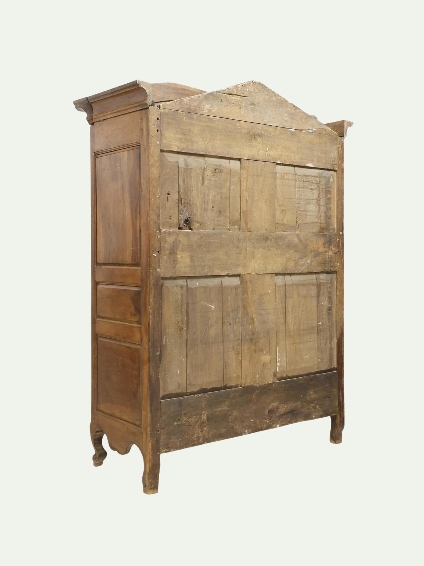 A vintage rustic wooden armoire cabinet with a weathered brown finish, featuring paneled doors and curved legs, isolated on a light off-white background.
