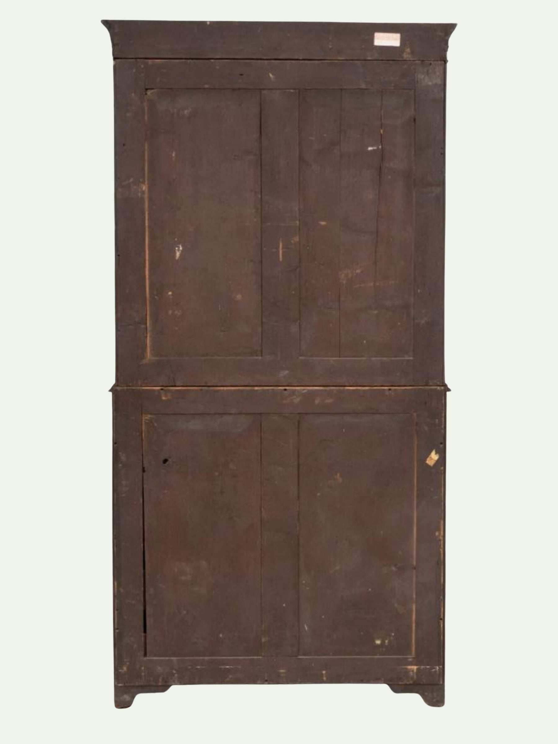 An antique wooden cabinet with two drawers on top and two doors below, featuring warm brown wood grain, decorative gold-toned metal drawer pulls, and light-colored inlay lines, set against a plain off-white background.