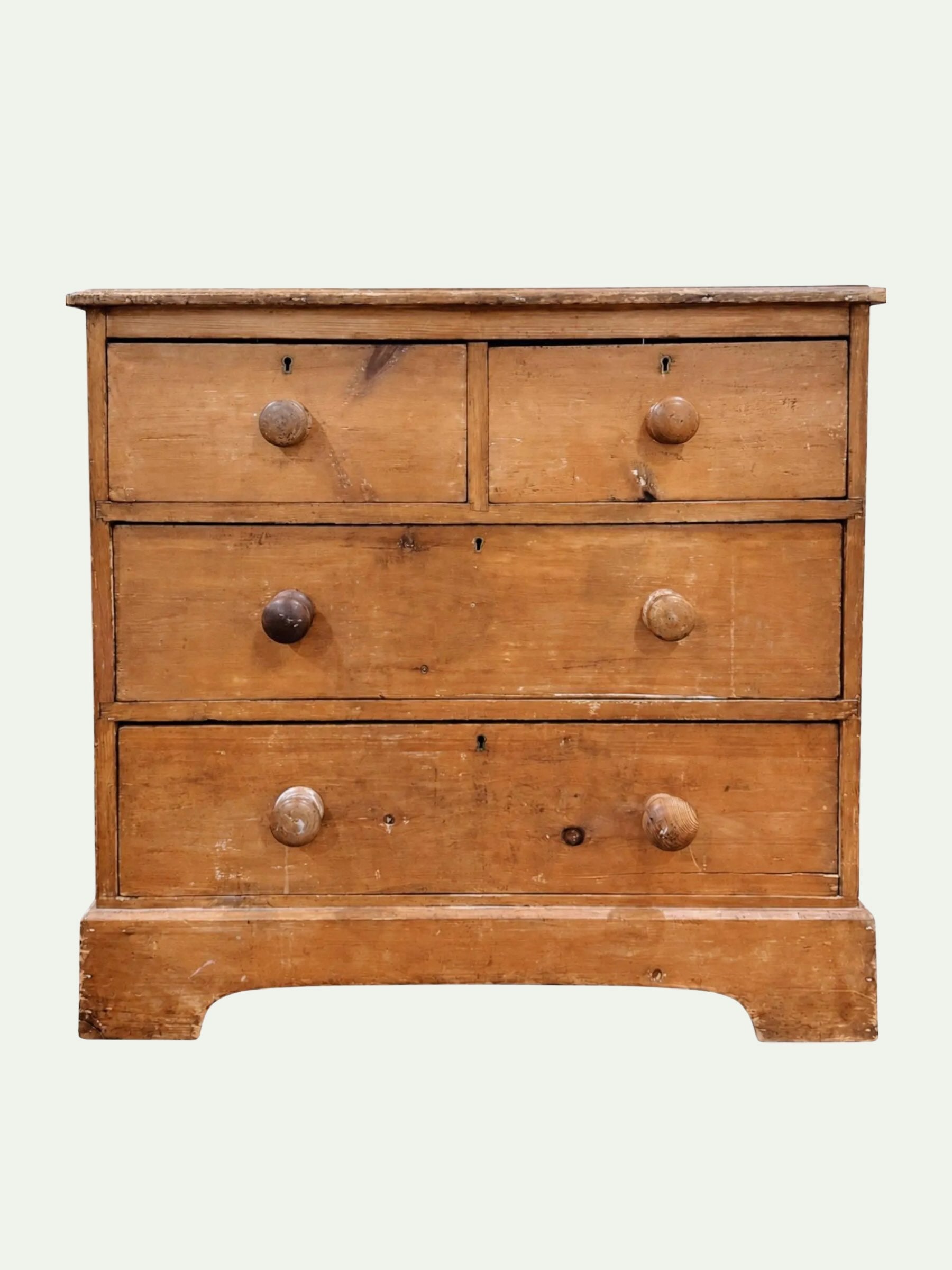 A vintage three-drawer wooden chest of drawers with a warm honey-brown finish and round wooden knobs, shown against a plain off-white background.