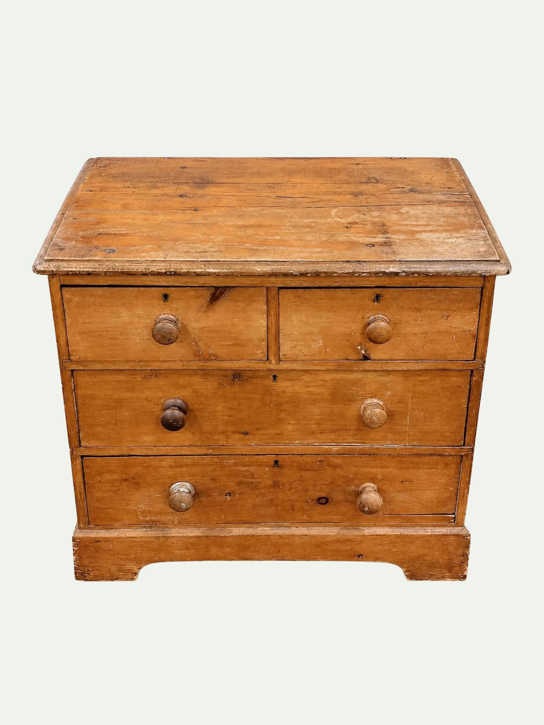 A vintage wooden chest of drawers with three front drawers, round metal knobs, and a flat top, shown against a plain light background.