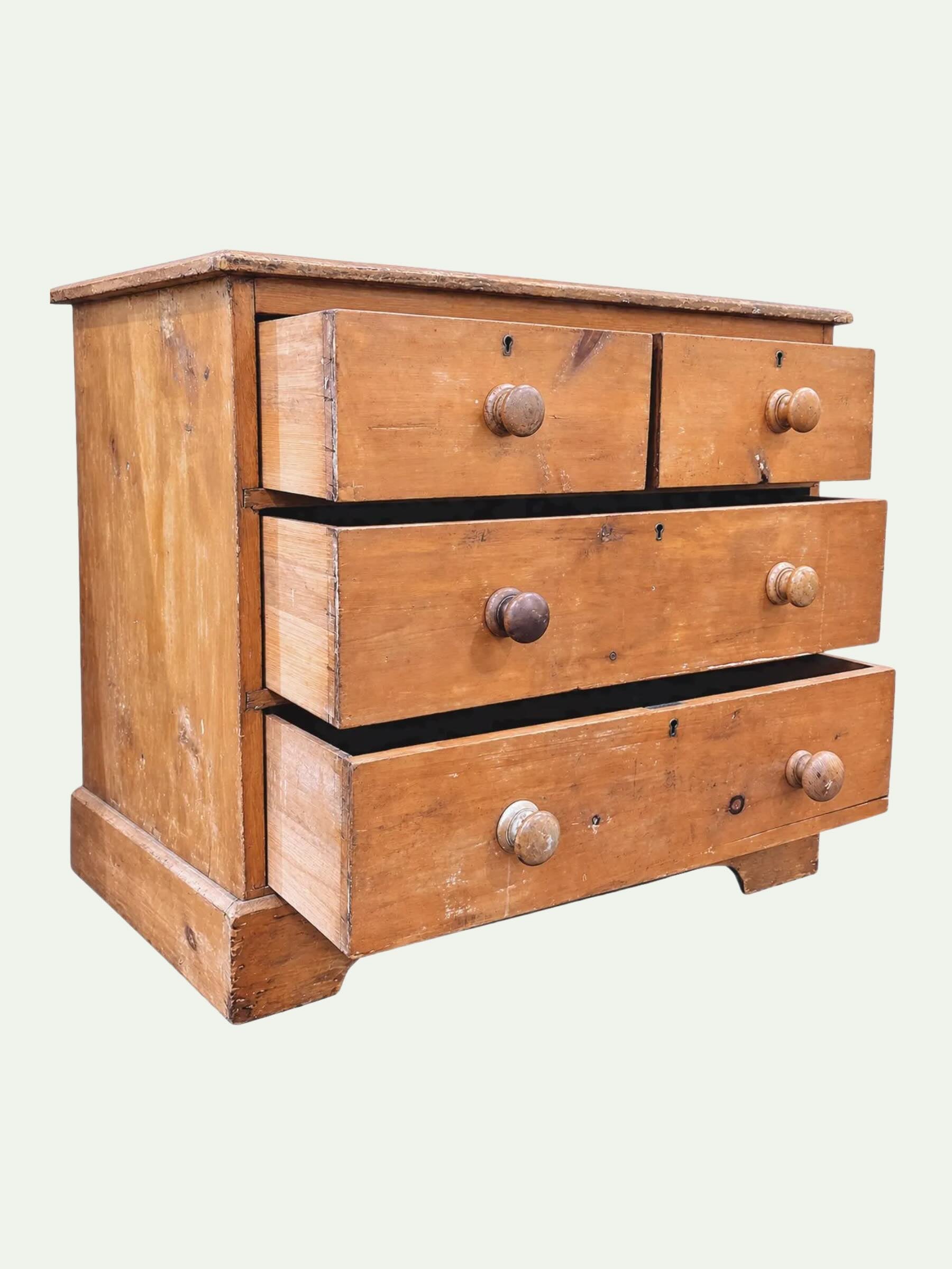 A vintage three-drawer wooden chest or nightstand with a warm medium-brown finish, featuring round wooden knobs and a slightly worn, rustic texture, shown against a plain off-white background.