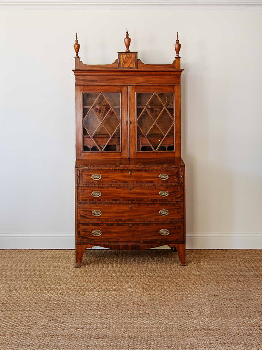 Wooden cabinet with glass doors on a beige carpet and white wall