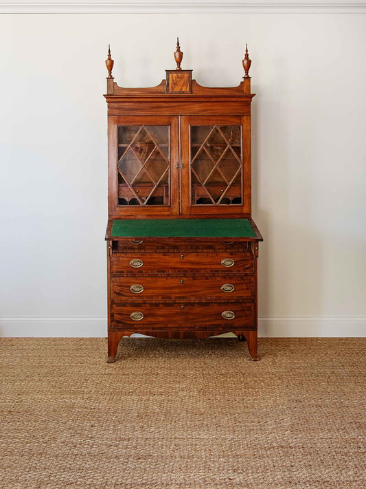 Wooden cabinet with glass doors and a green top on a beige carpet