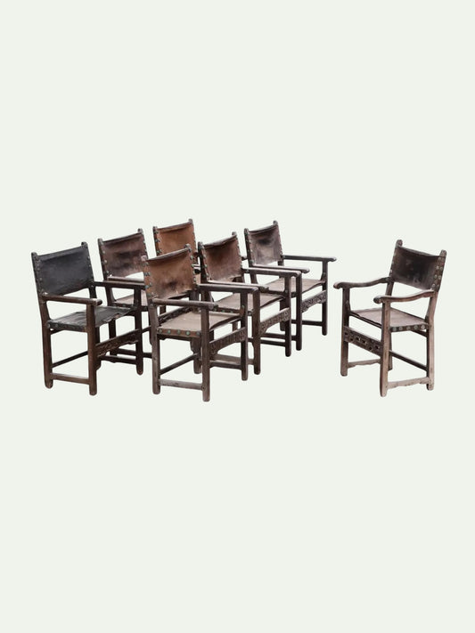 Set of eight wooden chairs with leather seats on a white background
