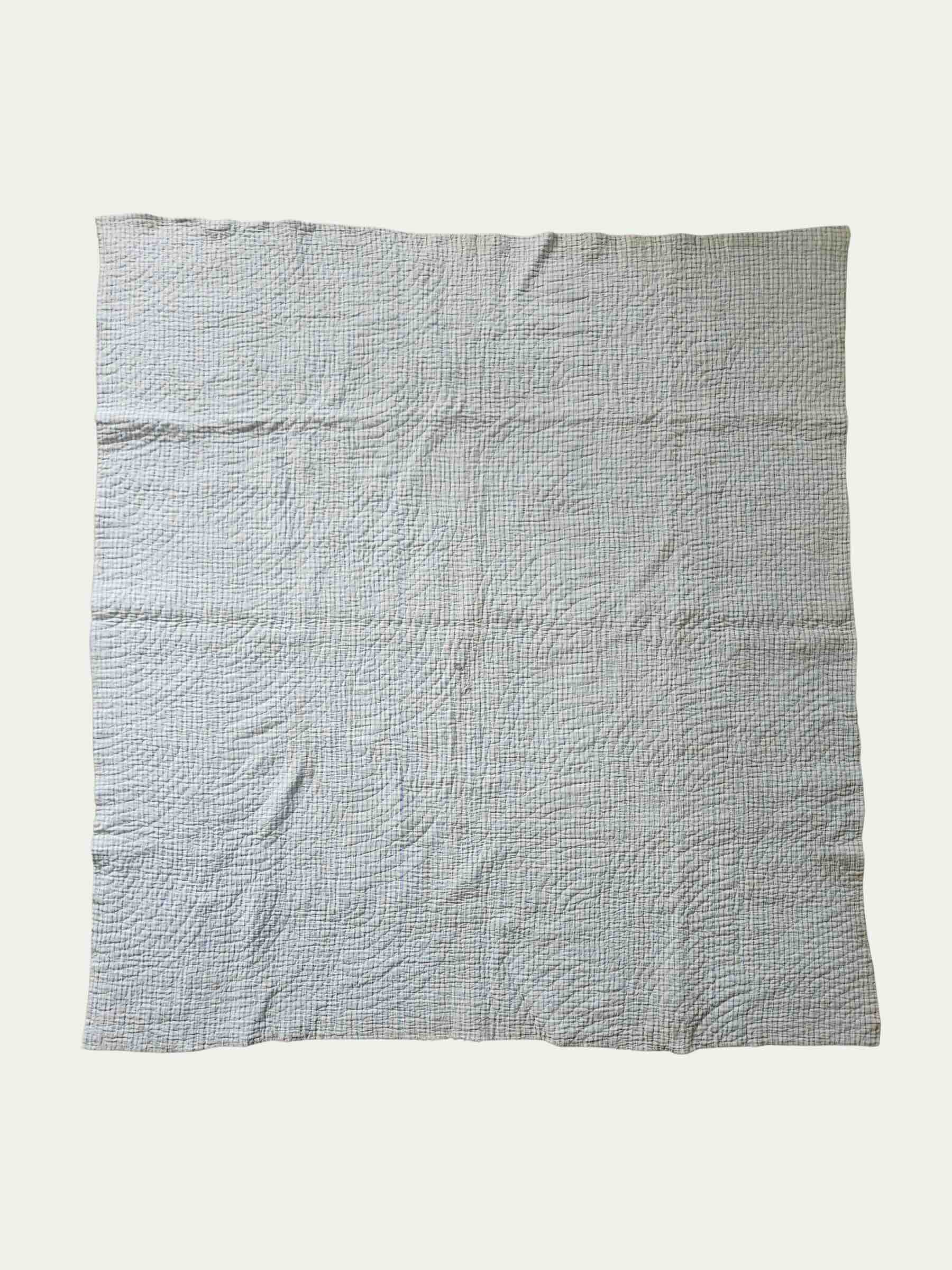 Textured gray quilt on a white background