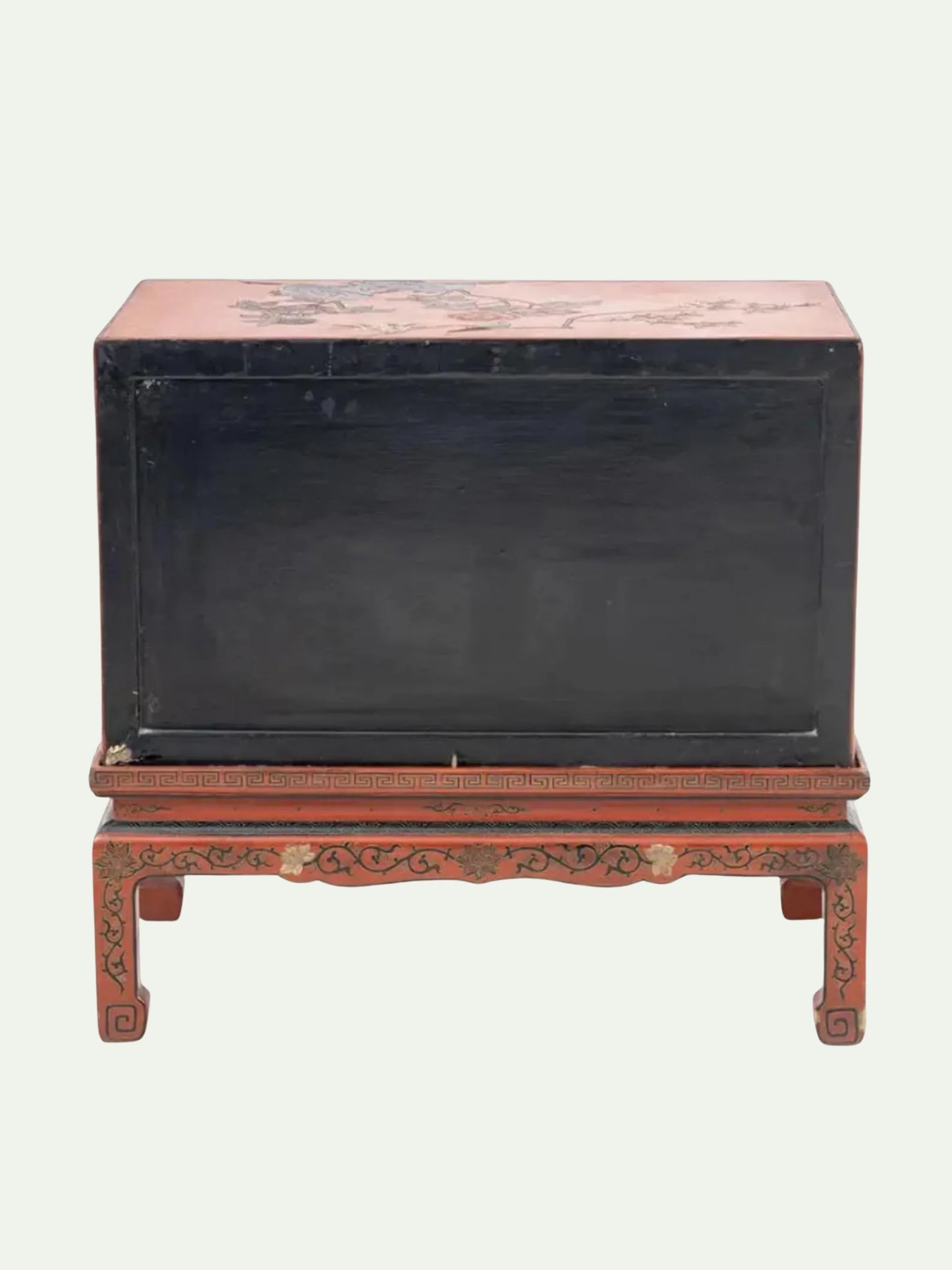 A vintage Chinese lacquered wooden chest with a black front panel and reddish-brown top and base, featuring hand-painted floral details.