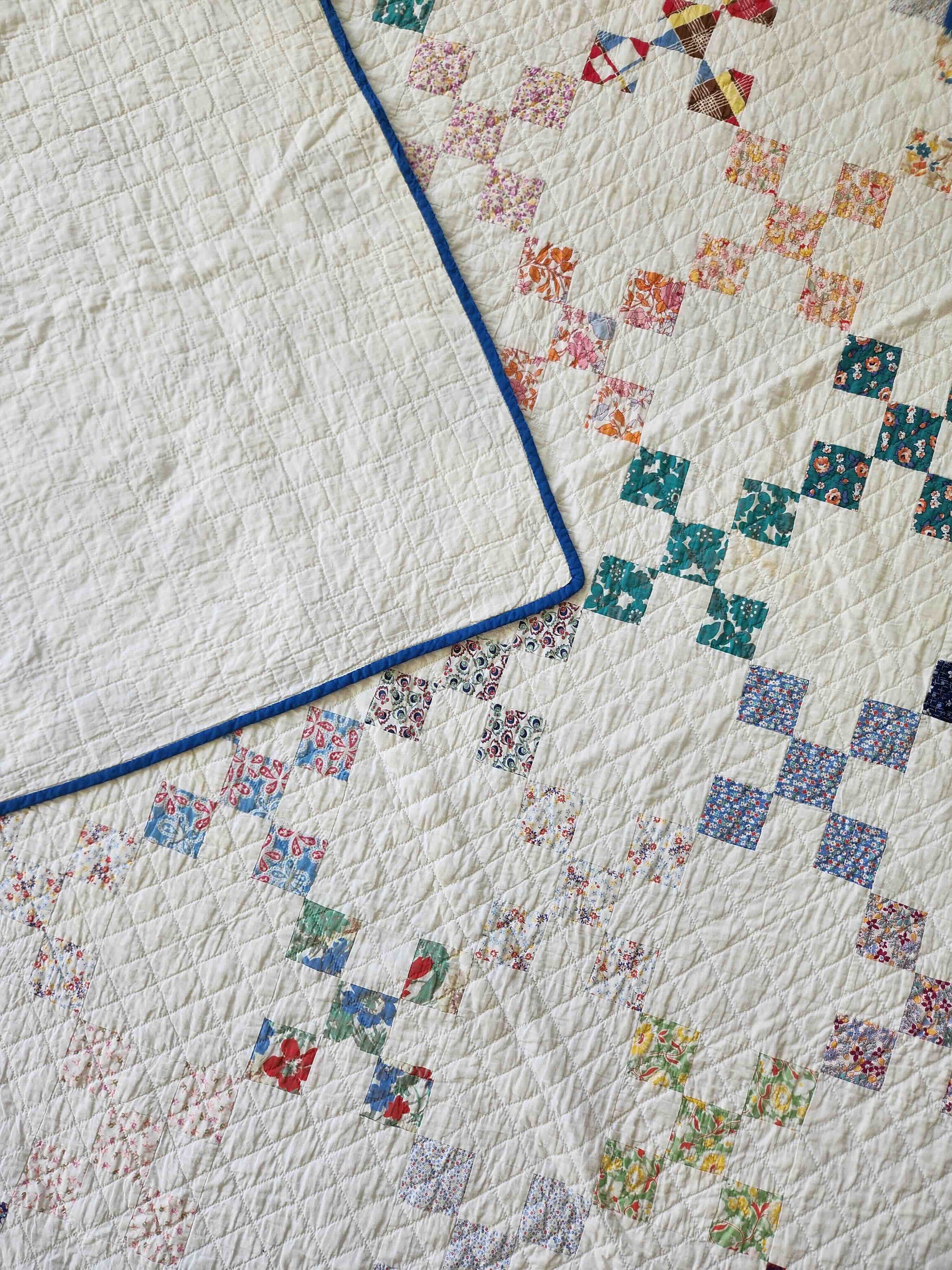 Close-up of a quilt with floral pattern and blue border