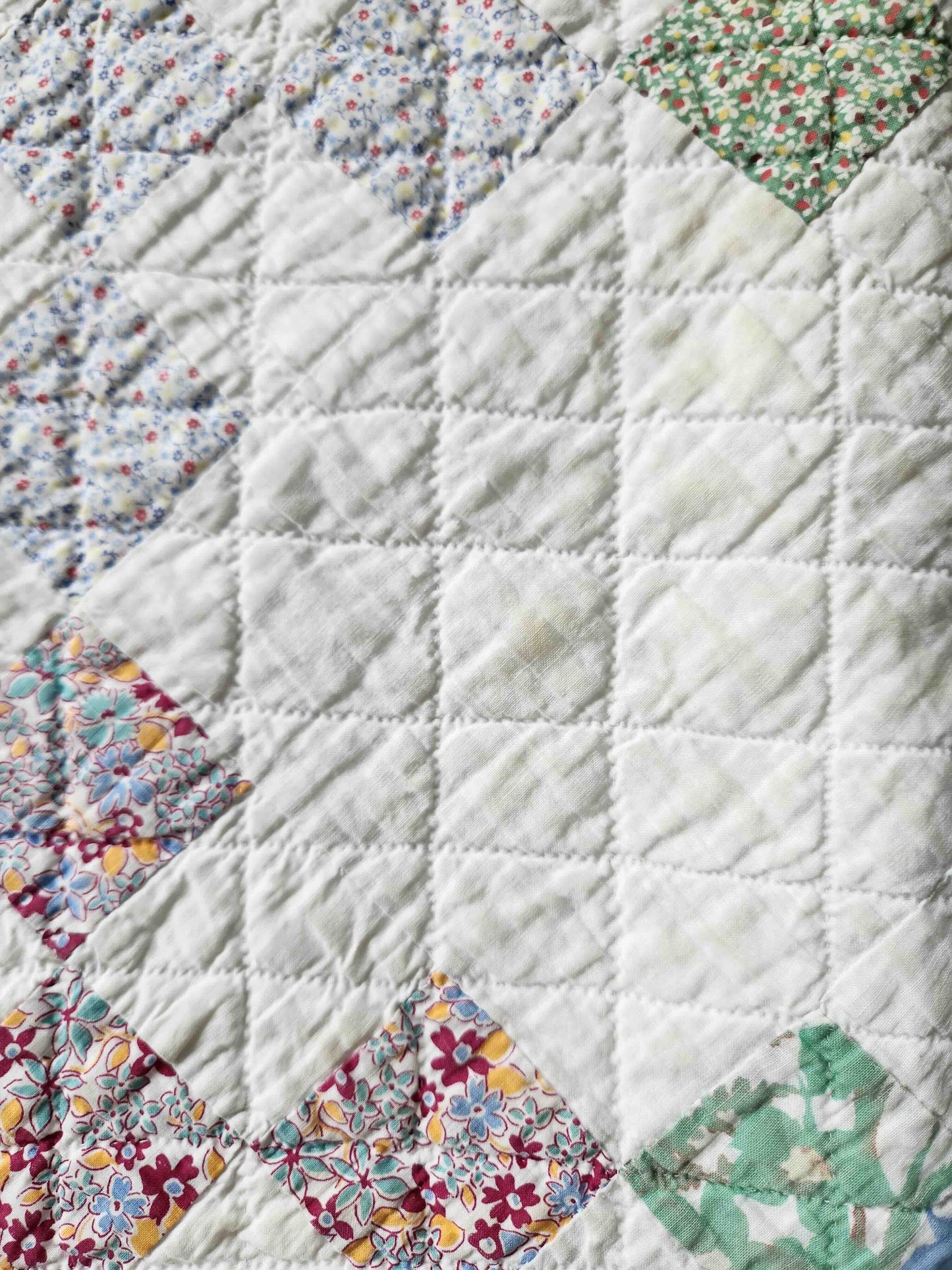 Quilt with floral patchwork design on a white background