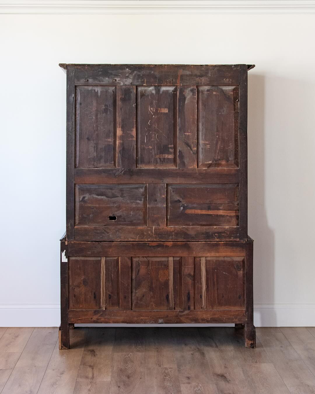 back of antique English oak cupboard with paneled doors and drawers