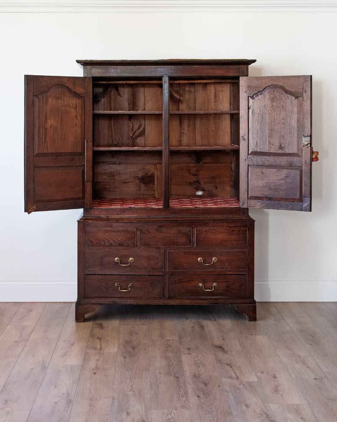 antique English oak cupboard with paneled doors and drawers