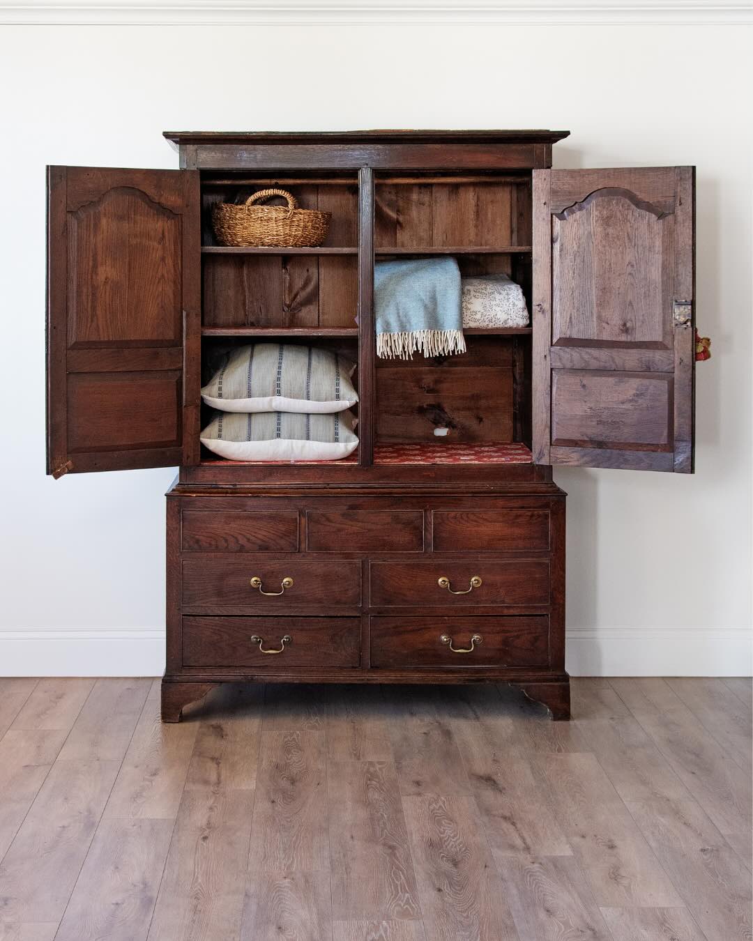 antique English oak cupboard with paneled doors and drawers