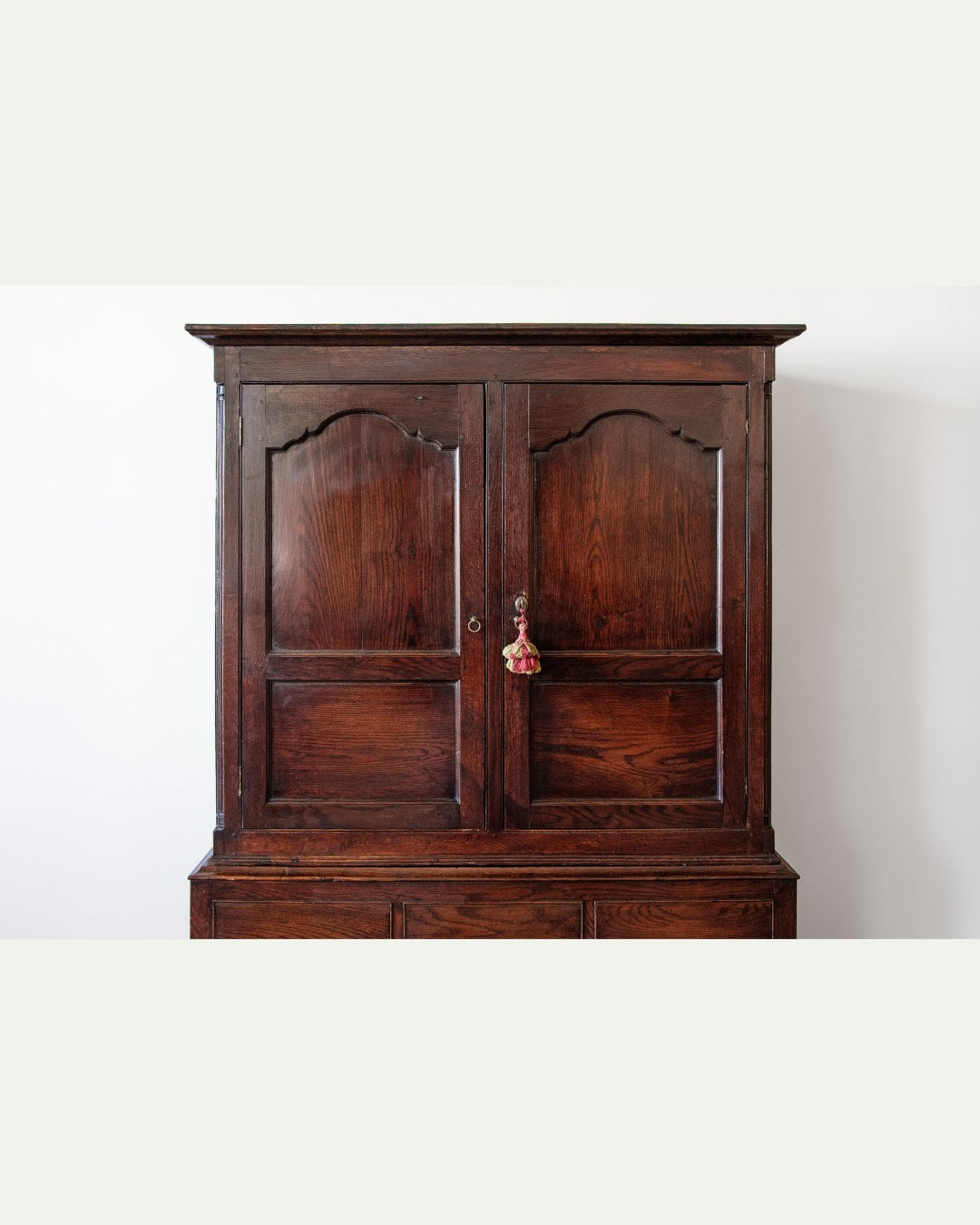 antique English oak cupboard with paneled doors and drawers