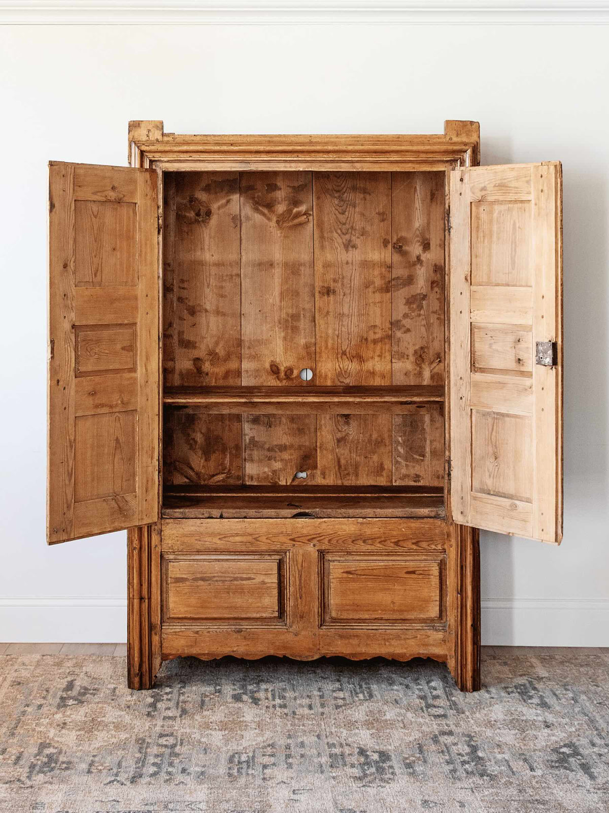 interior antique European country pine armoire with paneled doors lift top storage
