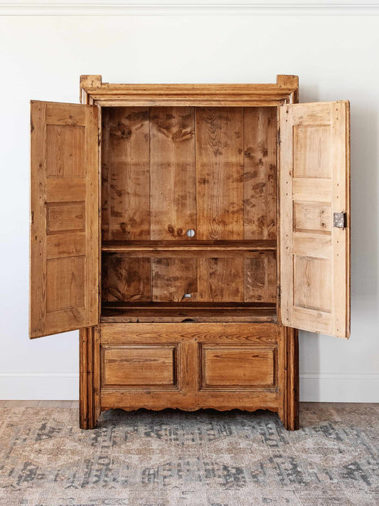 interior antique European country pine armoire with paneled doors lift top storage