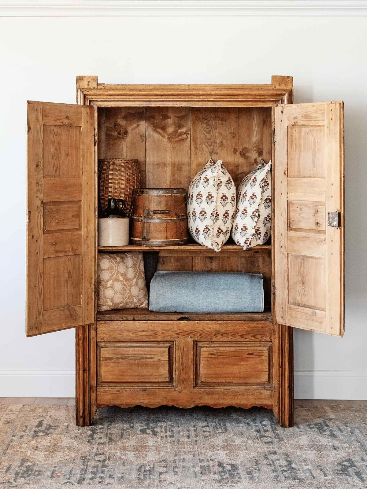 interior antique European country pine armoire with paneled doors lift top storage