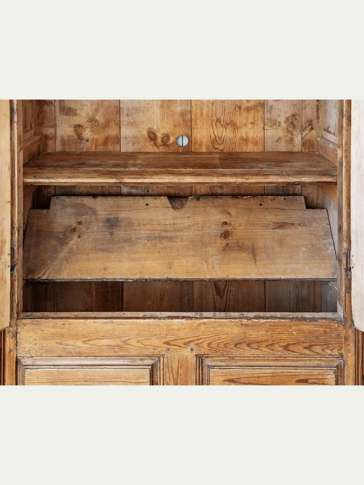 interior antique European country pine armoire with paneled doors lift top storage