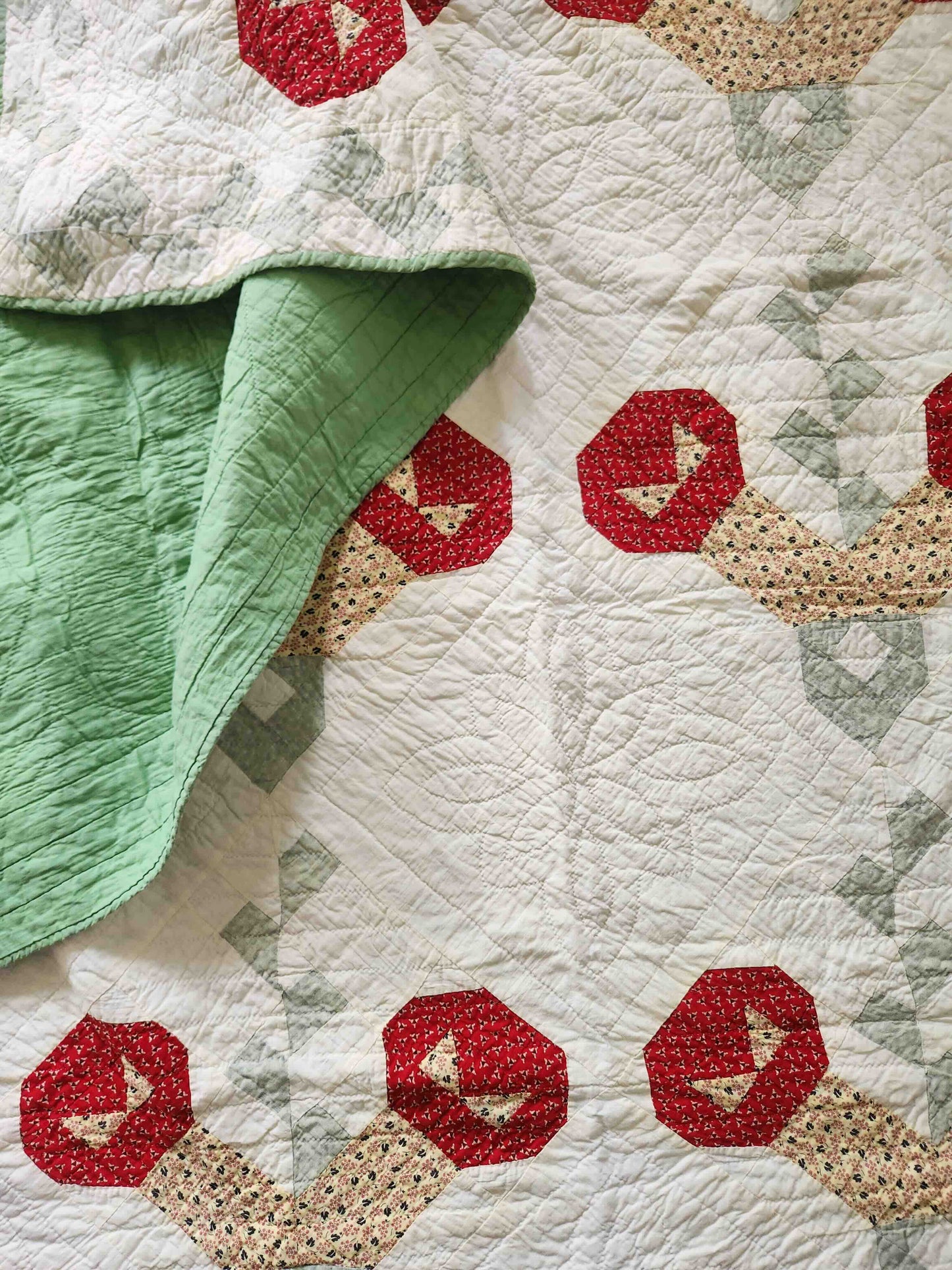 Quilt with red and beige geometric patterns on a white background