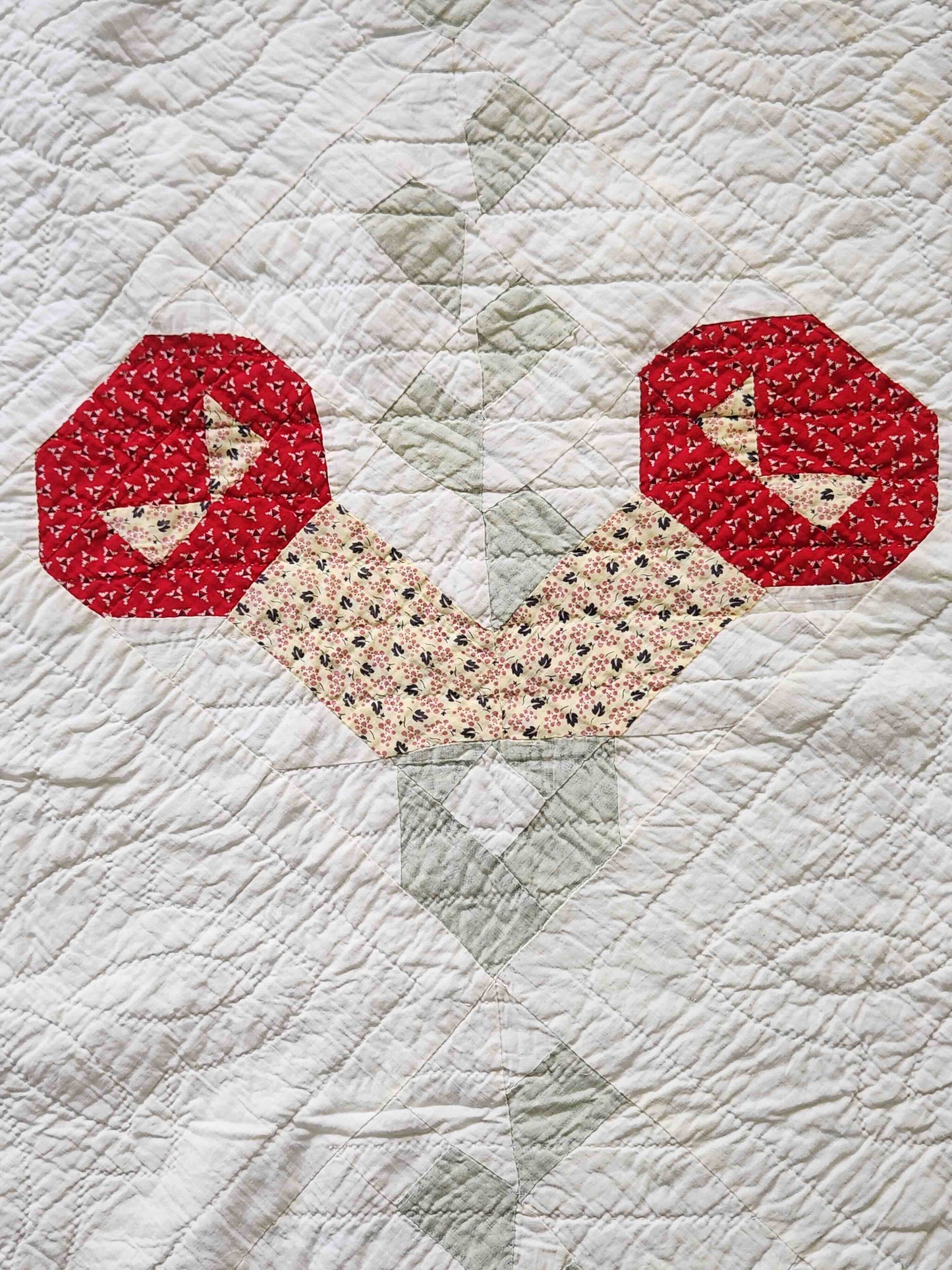 Quilt with red hexagonal patterns on a light background