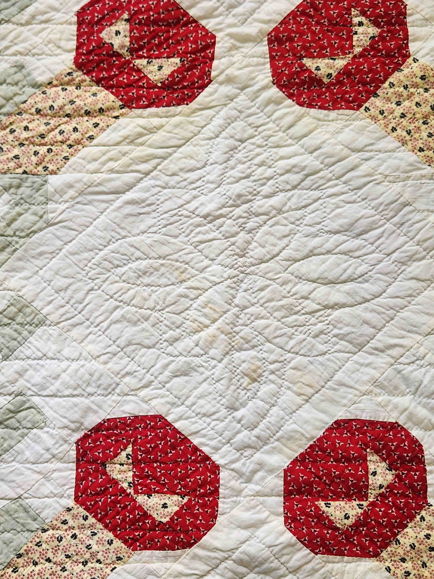 Quilt with red hexagonal patterns featuring birds on a beige background