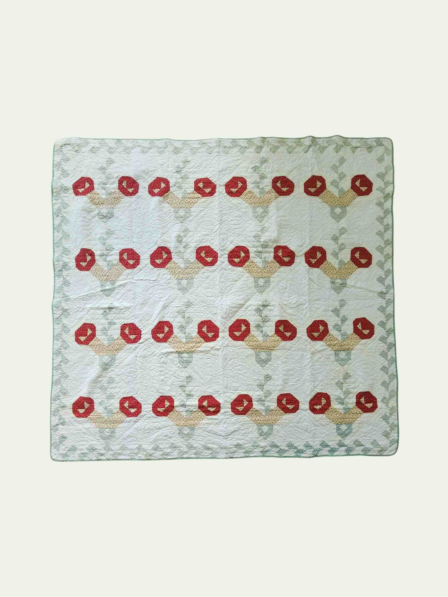 Quilt with red floral pattern on a white background