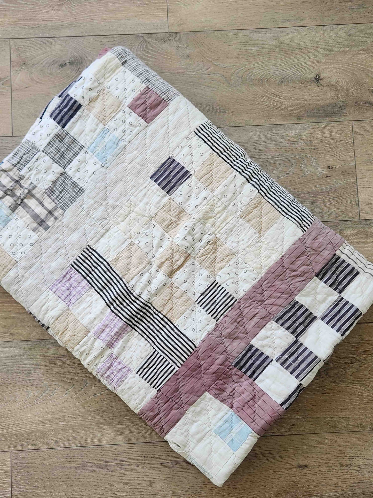 Patchwork quilt with geometric patterns on a wooden floor