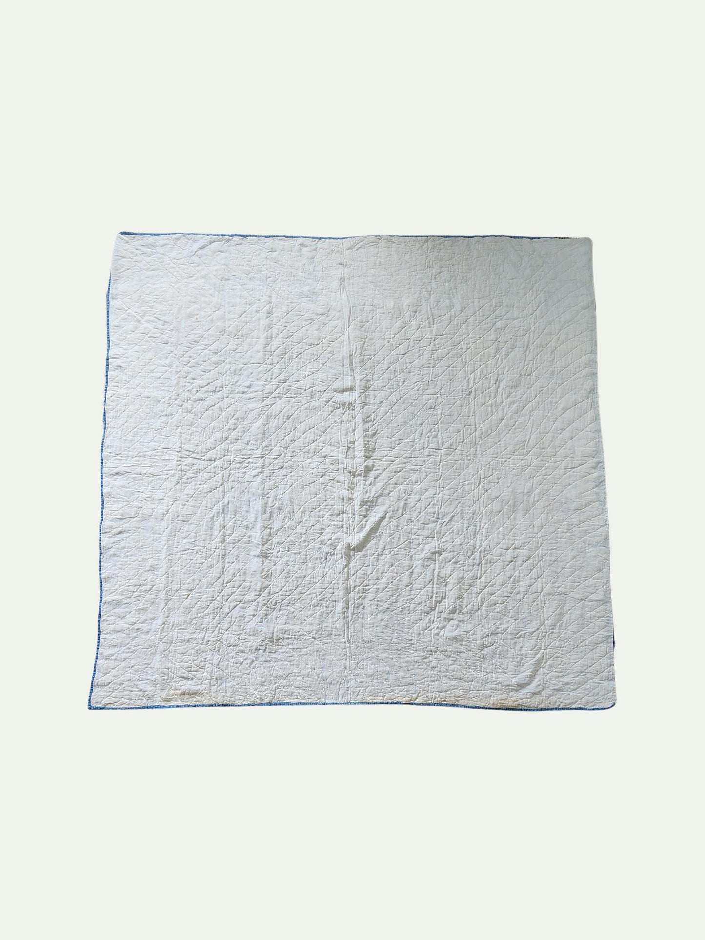 White quilted blanket on a white background
