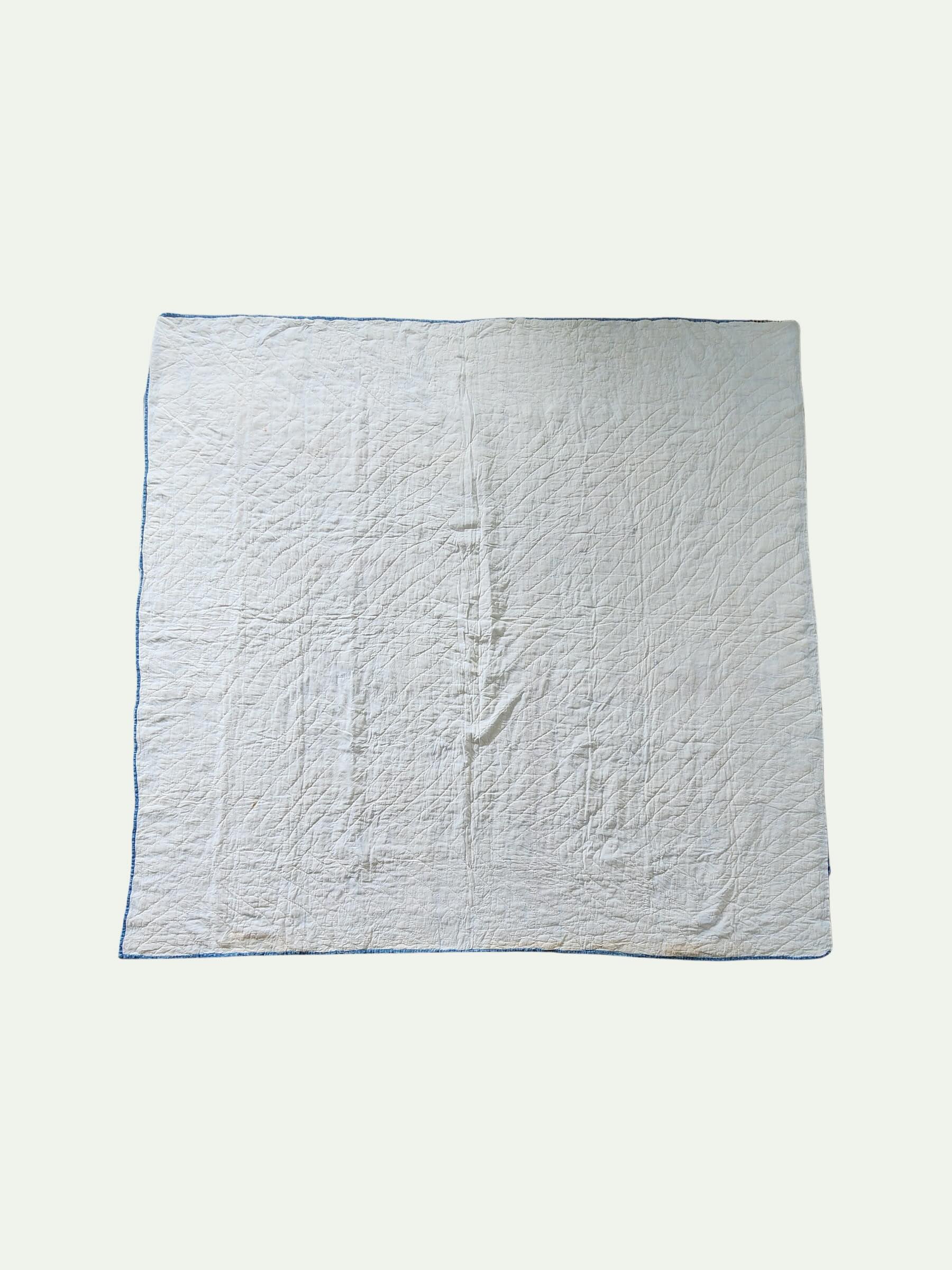 White quilted blanket on a white background