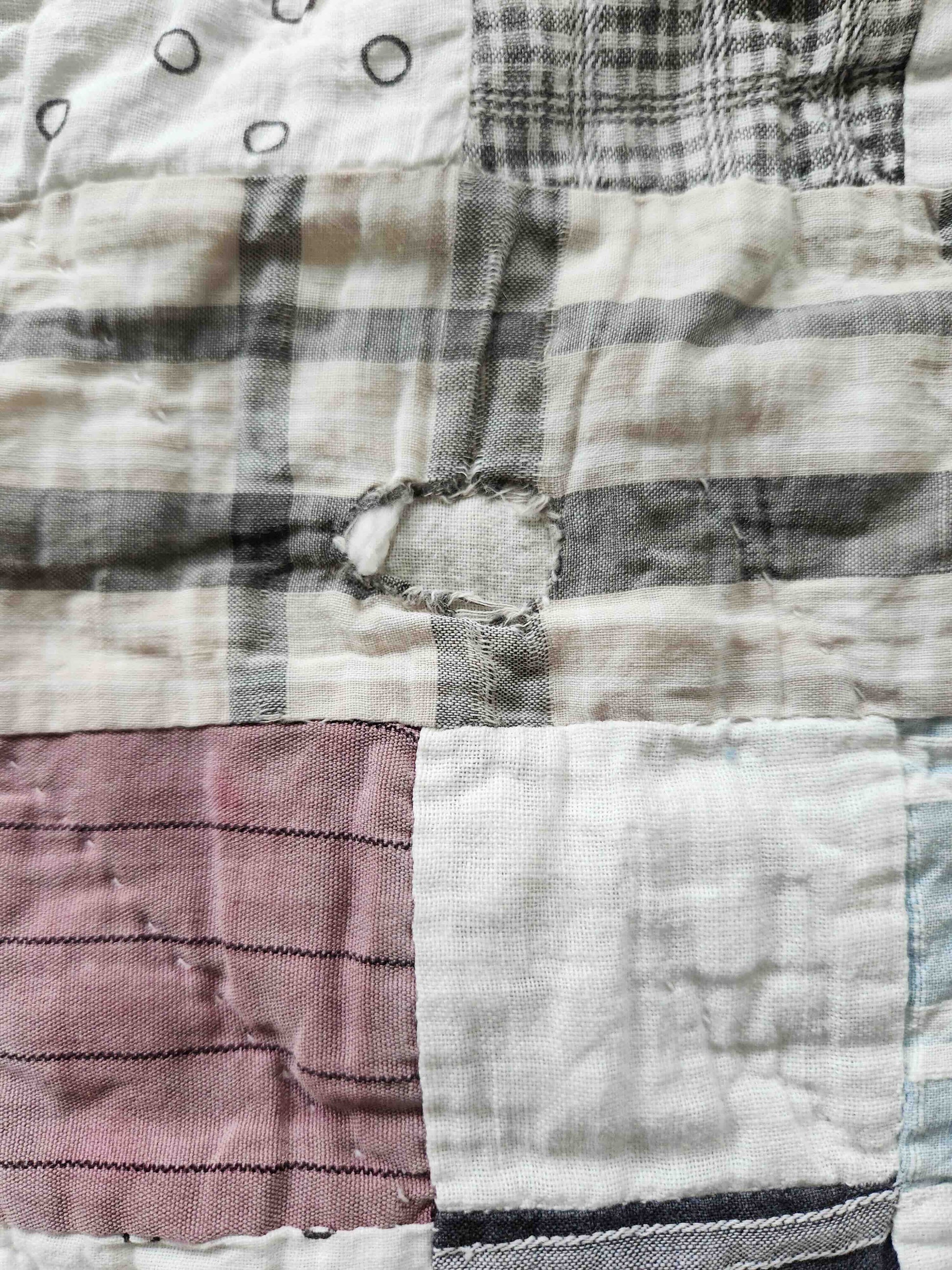 Close-up of a patchwork quilt with various fabric patterns and colors.