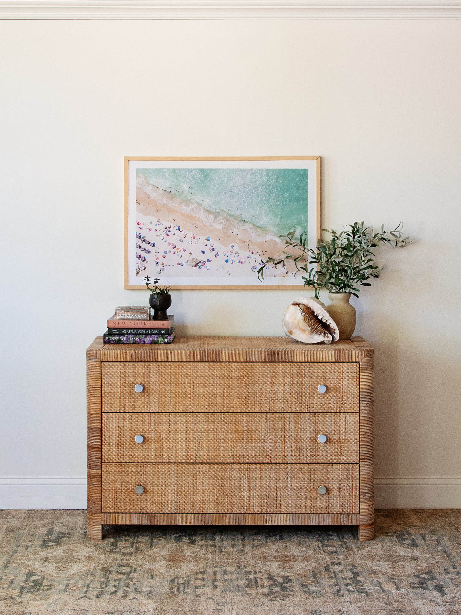 Wicker dresser with decorative items against a white wall