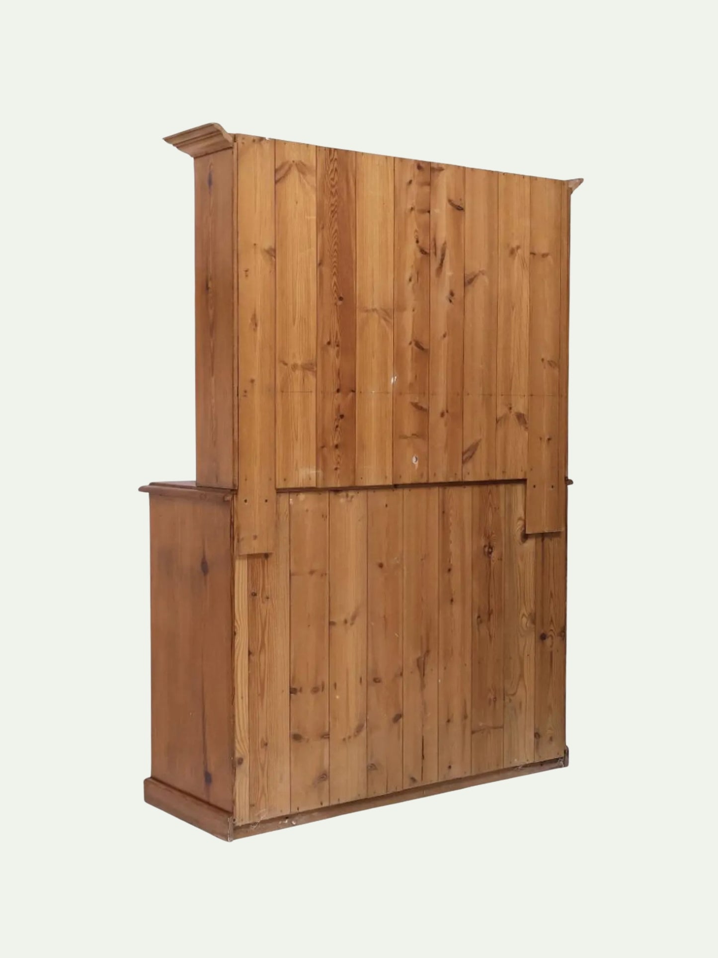 A tall wooden cabinet or wardrobe made of vertical pine panels, shown from a three-quarter angle against a plain off-white background.