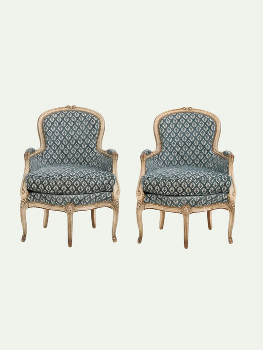 Pair of ornate chairs with patterned cushions on a light beige background