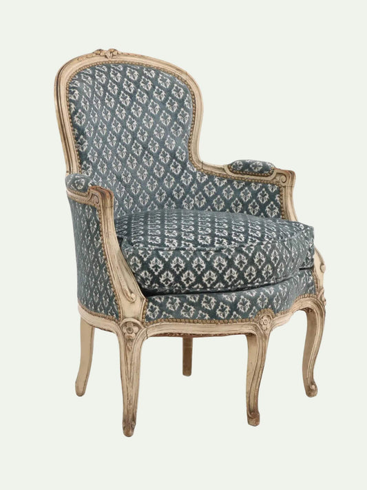 Decorative armchair with patterned blue fabric on a white background