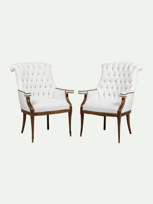 Two white upholstered chairs with wooden frames on a white background