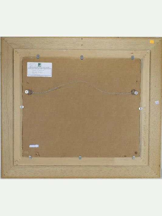 The back view of a framed artwork, showing a light natural wood frame, brown backing board, mounting wires, and small labels on a light off-white background.