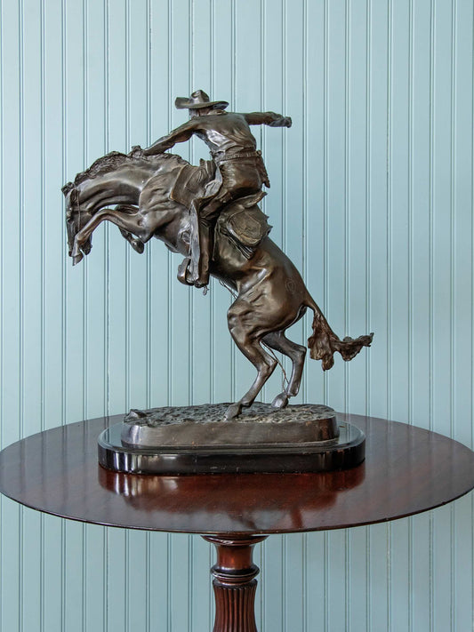 bronze statue of a cowboy riding a horse