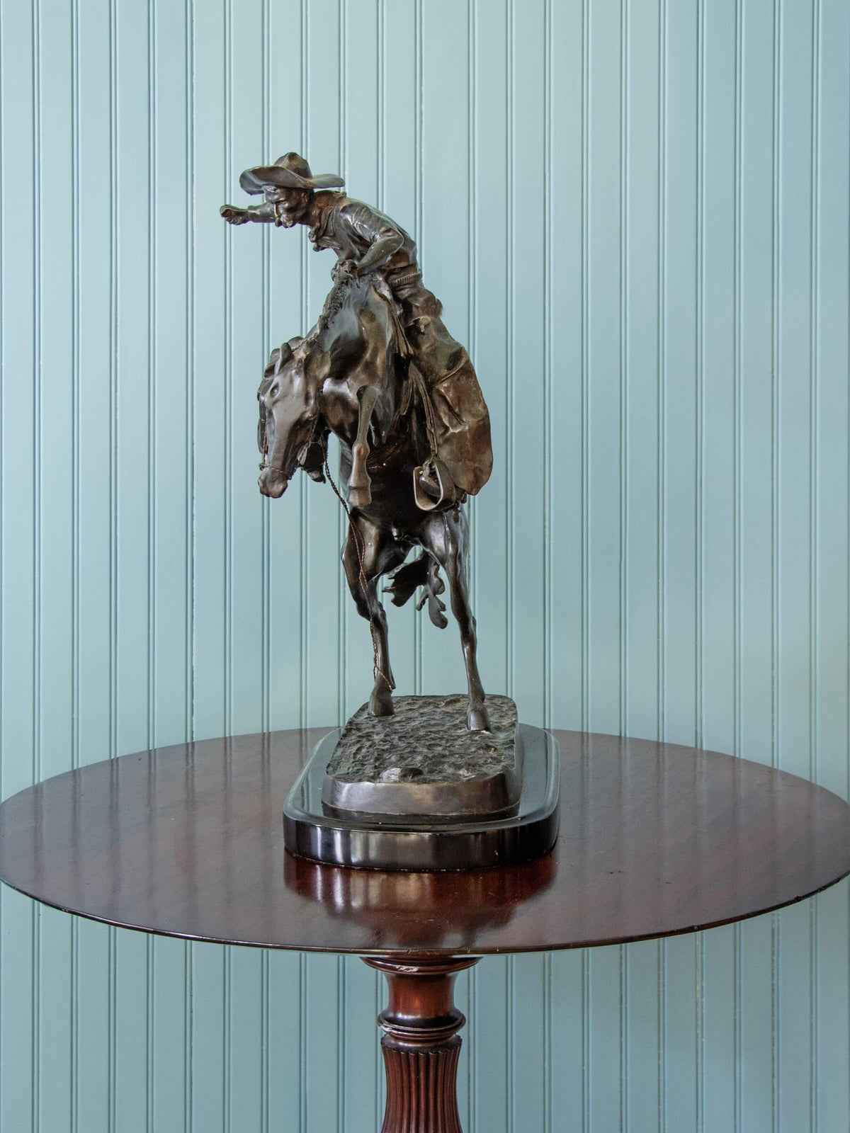 bronze statue of a cowboy riding a horse