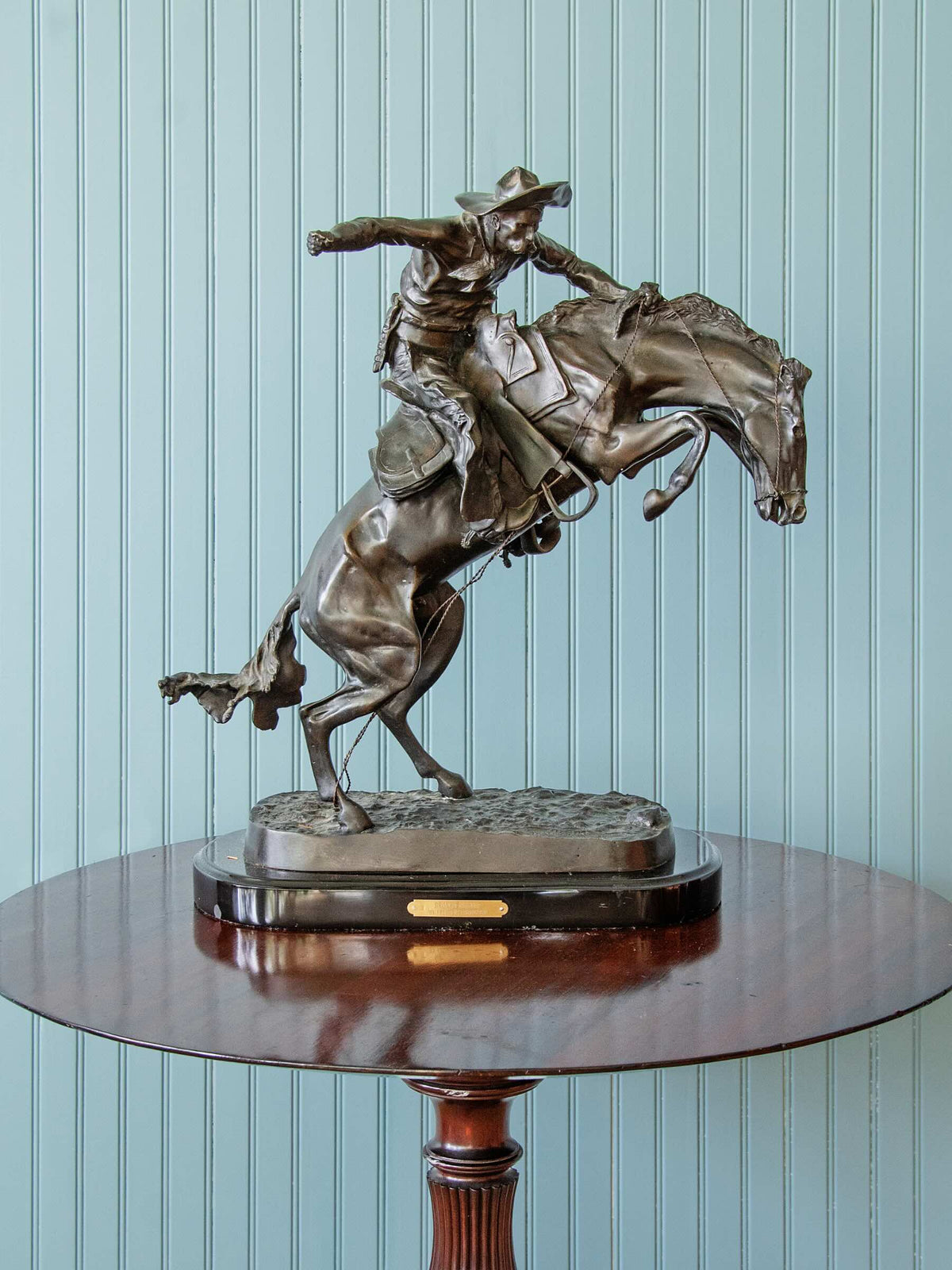 bronze statue of a cowboy riding a horse