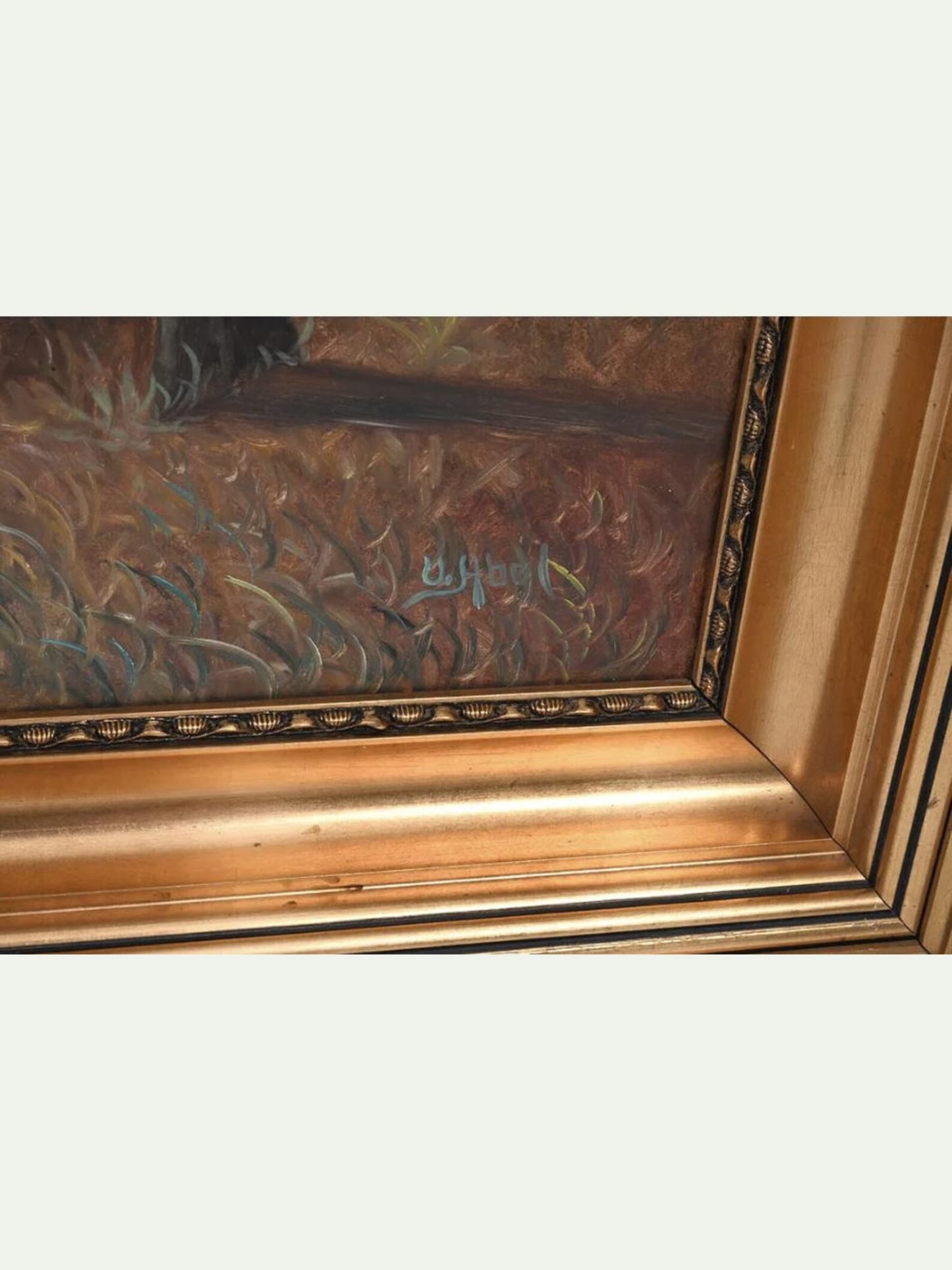 Close-up of an ornate gold picture frame with a painted scene visible inside, showing textured brushstrokes in brown, gold, and muted blue-green tones.