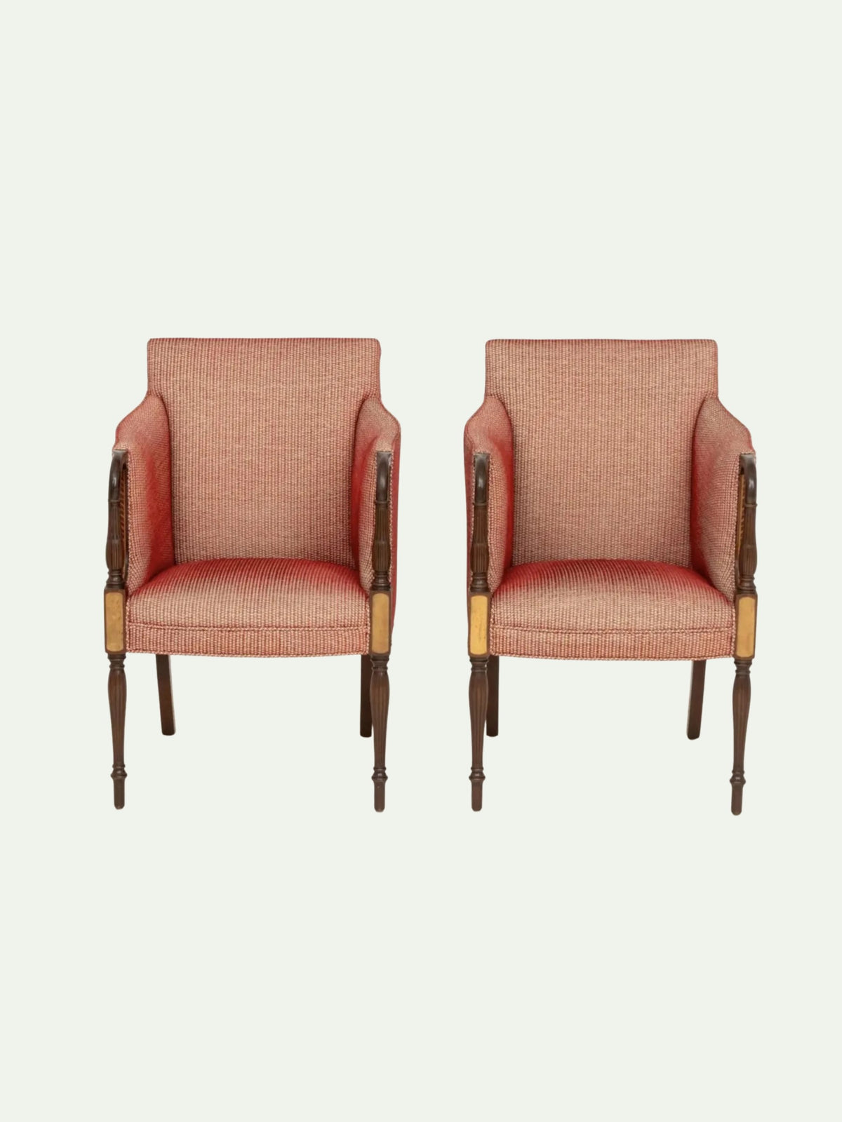 Two matching upholstered armchairs with textured pinkish-orange fabric and dark wood legs, shown side by side on a plain light background.