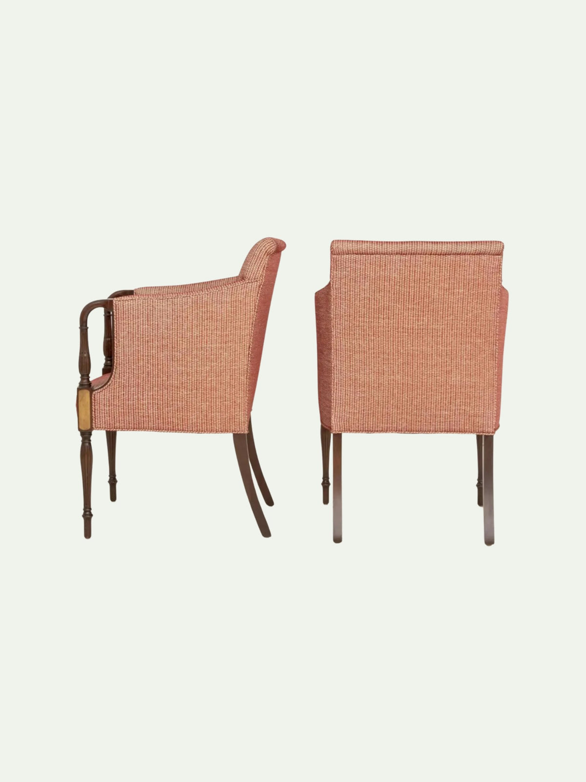 Two upholstered armchairs shown from the back on a plain light background. The chairs have textured peach-pink fabric seats and backs with dark brown wooden legs and armrests.