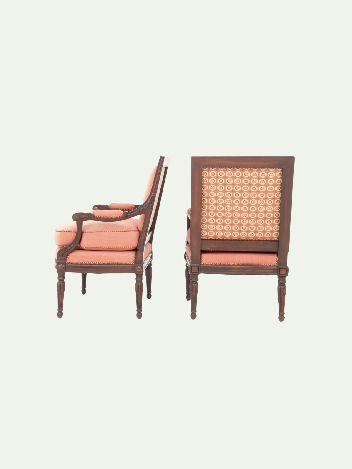 Two classic wooden armchairs with peach-pink cushions and patterned cane backs, shown from side and front angles against a light off-white background.